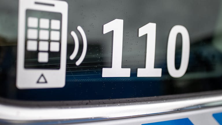 Die Nummer des Polizeinotrufs 110 steht auf der Scheibe eines Polizeifahrzeugs. (Foto: dpa Bildfunk, picture alliance/dpa | Daniel Karmann)