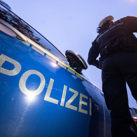 Symbolbild: Eine Polizistin steht neben einem Polizeifahrzeug (Foto: dpa Bildfunk, Marijan Murat/dpa (Symbolbild))