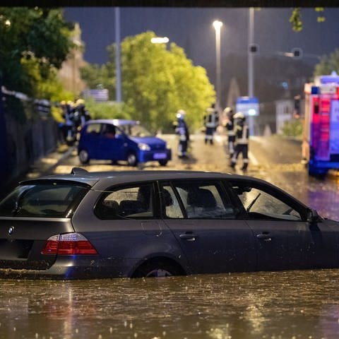 Ein Auto steht in Stuttgart in einer überfluteten Autounterführung. 