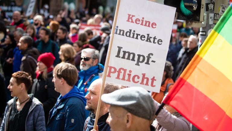 Ein Mann trägt auf einer Demonstration ein Schild mit der Aufschrift "Keine indirekte Impf-Pflicht".  (Foto: dpa Bildfunk, picture alliance/dpa | Christoph Schmidt)