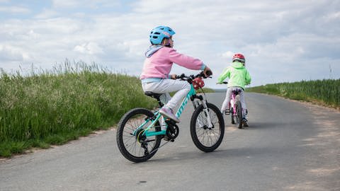 Kinder fahren auf einer Straße Fahrrad (Foto: dpa Bildfunk, picture alliance / Fotostand | Fotostand / K. Schmitt)