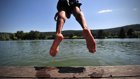 Ein junger Mann springt in den Badesee in Plüderhausen: Nicht alle lassen sich aktuell von den Blaualgen dort abschrecken. (Foto: dpa Bildfunk, picture alliance / dpa | Jan-Philipp Strobel)