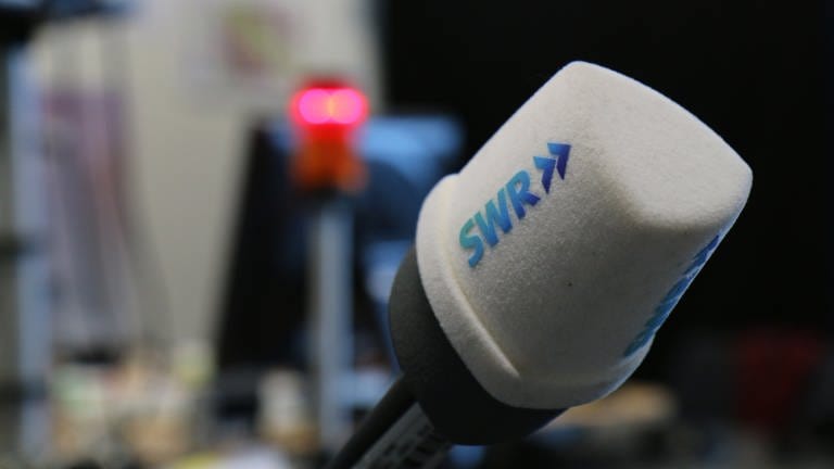 SWR Mikrofon vor unscharfem Hintergrund mit Rotlicht (Foto: SWR)