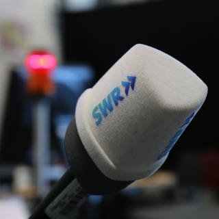 SWR Mikrofon vor unscharfem Hintergrund mit Rotlicht