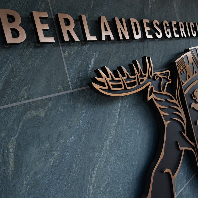 An dem Gebäude des Oberlandesgerichts (OLG Stuttgart) hängt unter dem Schriftzug das Wappen Baden-Württembergs. (Foto: dpa Bildfunk, picture alliance/dpa | Sebastian Gollnow)