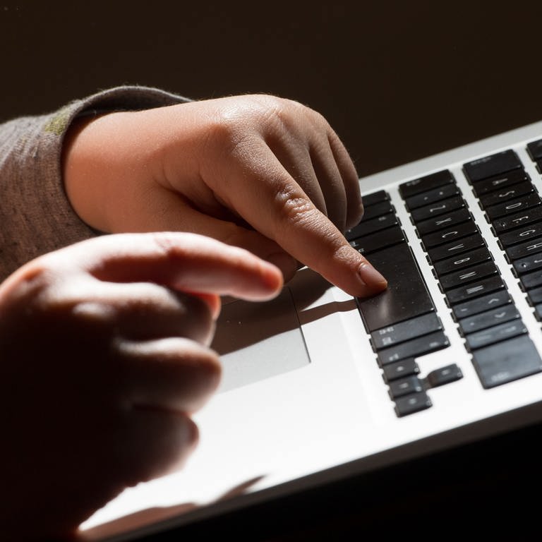 Ein Mädchen tippt auf einer Tastatur. 