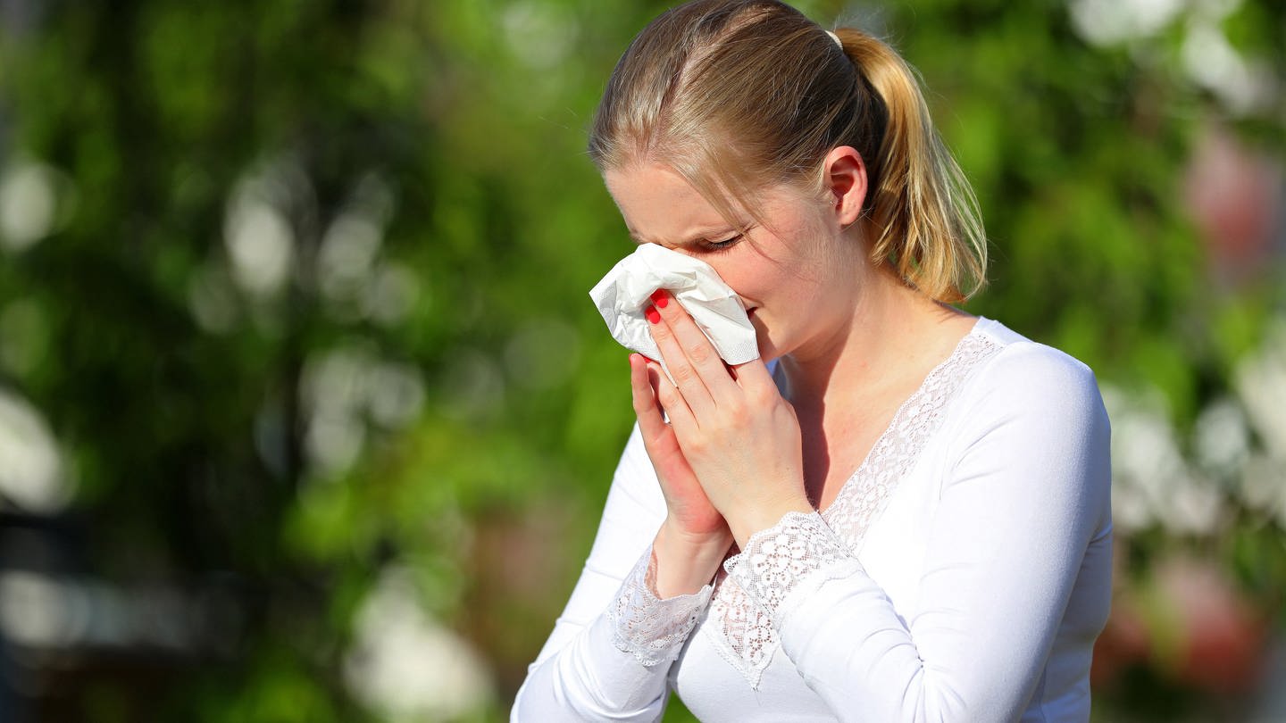 Eine Frau putzt sich im Freien die Nase mit einem Taschentuch (Foto: dpa Bildfunk, picture alliance / pressefoto_korb | Micha Korb)