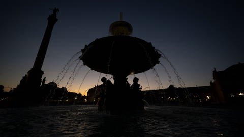 Ein Brunnen auf dem Schlossplatz, die Jubiläumssäule und das Neue Schloss sind am frühen Morgen unbeleuchtet.  (Foto: dpa Bildfunk, picture alliance/dpa | Marijan Murat)