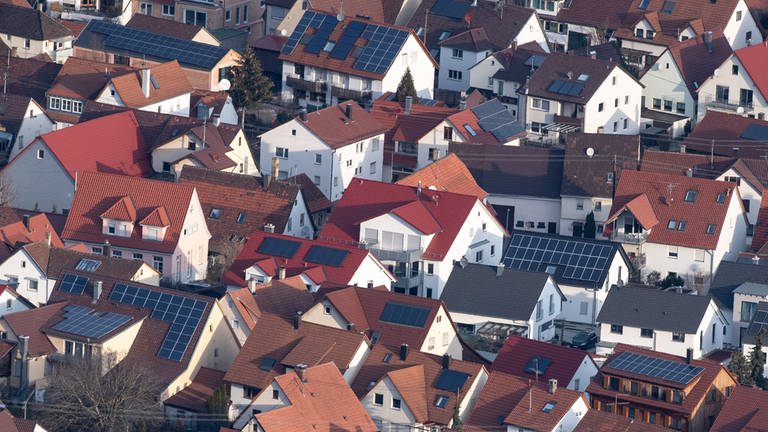 Auf den Dächern von mehreren Häusern sind Photovoltaikanlagen auf dem Dach installiert.