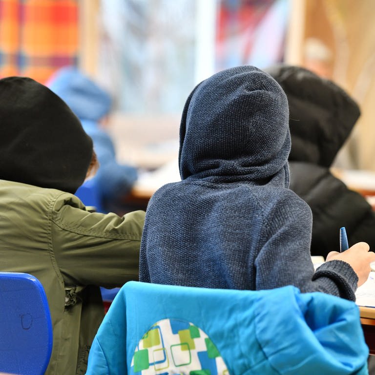 Schülerinnen und Schüler arbeiten während einer Lüftungsphase im Klassenzimmer in warmer Kleidung. (Foto: dpa Bildfunk, picture alliance / Frank May | Frank May)