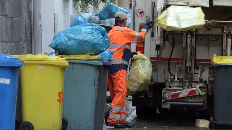 Ein Mitarbeiter der Entsorgungsbetriebe wirft Abfall in ein Müllfahrzeug (Foto: dpa Bildfunk, picture alliance/Stefan Puchner/dpa)