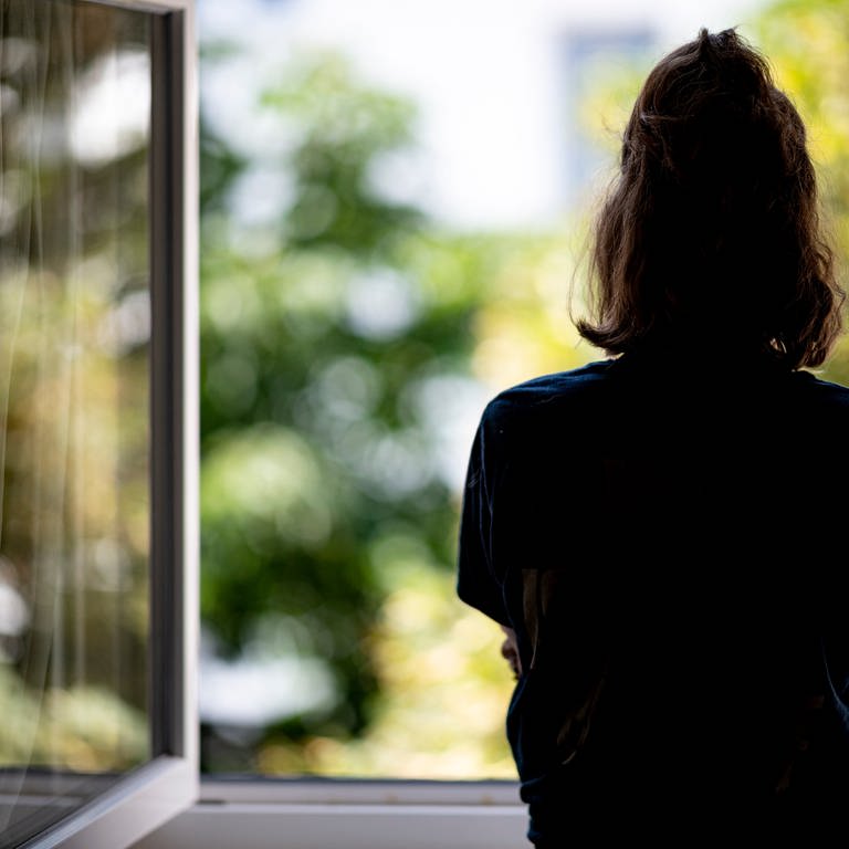 Eine Frau steht am Fenster (Symbolbild) (Foto: dpa Bildfunk, picture alliance/dpa | Fabian Sommer)