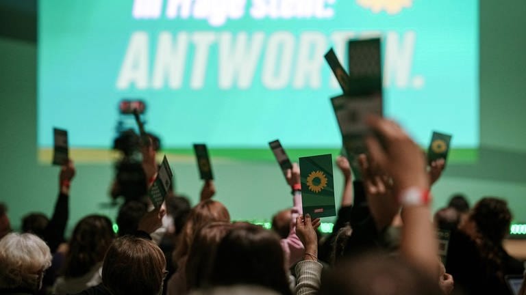 Delegierte stimmen beim Grünen-Bundesparteitag 2022 in Bonn über Anträge ab. Im Hintergrund eine Leinwand. (Foto: dpa Bildfunk, picture alliance/dpa | Kay Nietfeld)