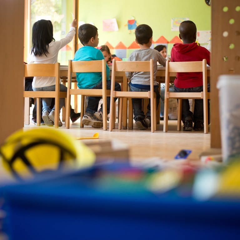 Kindergartenkinder sitzen an einem Tisch in Stuttgart (Baden-Württemberg) in einer Kindertagesstätte.