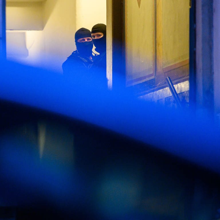 Zwei Maskierte Polizisten durchsuchen ein Gebäude.  (Foto: dpa Bildfunk, picture alliance/dpa/dpa-Zentralbild | Robert Michael (Symbolbild))