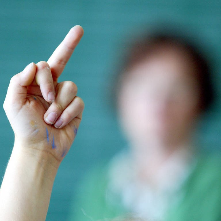 Schülerin zeigt Lehrerin den Mittelfinger. (Foto: IMAGO, IMAGO / photothek)