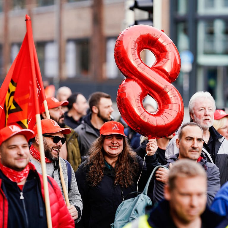 Eine Teilnehmerin hält in der Innenstadt bei einer Aktion der Gewerkschaft IG Metall im Tarifkonflikt der Metall- und Elektroindustrie eine rote Acht in die Höhe. (Foto: dpa Bildfunk, picture alliance/dpa | Uwe Anspach)