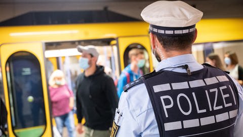 Polizeibeamte kontrollieren an einer Haltestelle im öffentlichen Nahverkehr die Einhaltung der Maskenpflicht. (Foto: dpa Bildfunk, picture alliance/dpa | Sebastian Gollnow)