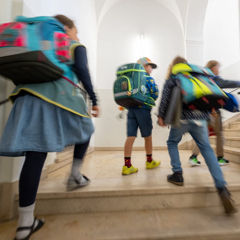 Grundschüler mit Schulranzen auf einer Treppe (Symbolbild)