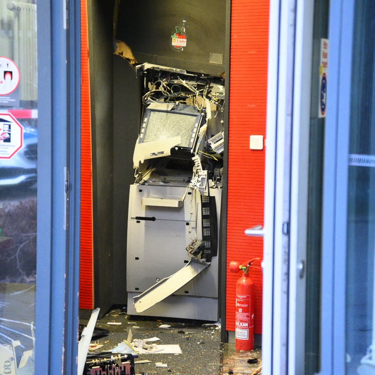 Ein gesprengter Geldautomat ist in einem Bankgebäude zu sehen. 