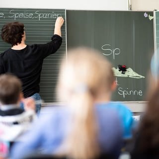 Eine Lehrerin schreibt in einer Grundschule Wörter mit «Sp» am Anfang an eine Tafel. (Foto: dpa Bildfunk, picture alliance/dpa | Sebastian Gollnow)