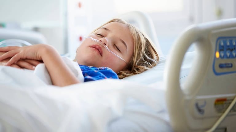 Ein Kind liegt in einem Bett in einer Kinderklinik. (Foto: IMAGO, IMAGO / Shotshop)