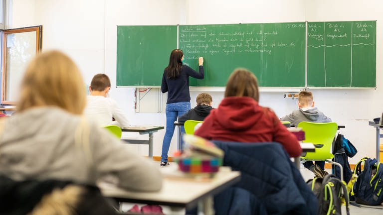 Schülerinnen und Schüler einer fünften Klasse der Johanniter Realschule Heitersheim (Kreis Breisgau-Hochschwarzwald) sitzen während dem Unterricht in ihrem Klassenzimmer. 