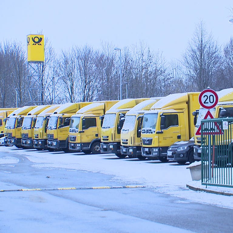 Zahlreiche Post-Zustellfahrzeuge stehen am 20.1.23 schneebedeckt auf dem Parkplatz der Niederlassung in Reutlingen (Foto: SWR)