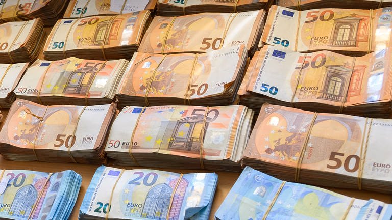 Mehrere Geldbündel liegen auf einem Tisch. (Foto: dpa Bildfunk, picture alliance/dpa | Silas Stein)