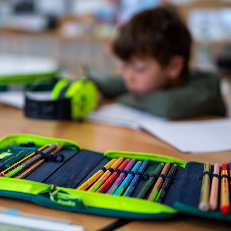 Ein Junge einer 2. Klasse arbeitet in einer Grundschule im Klassenzimmer an einem Arbeitsblatt.