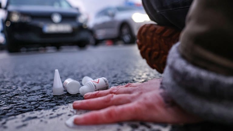 Ein Klimaaktivist hat sich mit Kleber auf der Straße festgeklebt. 