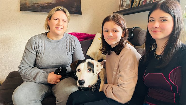 Mutter Kathrin Frick, Hund Mabu und ihre Töchter Anna und Lilly im gemeinsamen Wohnzimmer. (Foto: SWR)