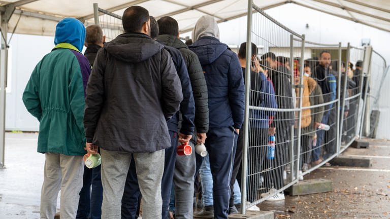 In der Landeserstaufnahmestelle (LEA) warten Flüchtlinge in einer Schlange vor der Essensausgabe.  (Foto: dpa Bildfunk, picture alliance/dpa | Stefan Puchner)