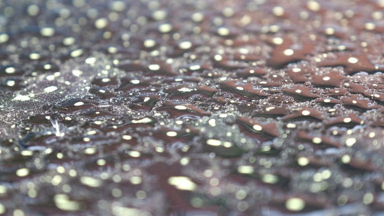 Wassertropfen mit Saharastaub bilden auf einem Autodach ein Muster (Foto: dpa Bildfunk, picture alliance/dpa | Bernd Weißbrod)