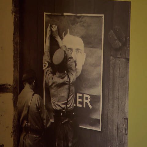 Plakat von Adolf Hitler wird aufgehängt