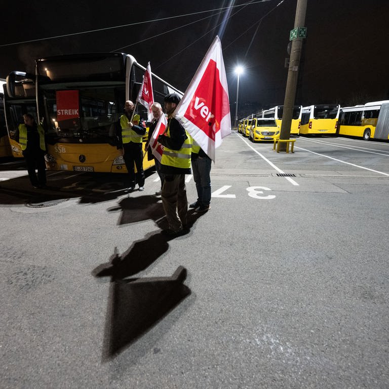 Teilnehmerinnen und Teilnehmer eines Warnstreiks stehen in einem Busdepot der Stuttgarter Straßenbahnen AG (SSB).  (Foto: dpa Bildfunk, picture alliance/dpa | Marijan Murat)