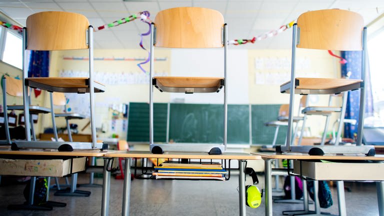 Stühle stehen nach Schulschluss auf den Tischen in einem Unterrichtsraum einer Grundschule.