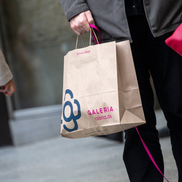 Ein Mann trägt eine Papiertasche mit dem Logo der Kaufhauskette Galeria Karstadt Kaufhof. (Foto: dpa Bildfunk, picture alliance/dpa | Thomas Banneyer)