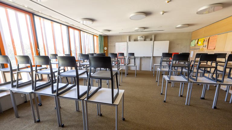 Stühle stehen auf den Tischen in einem leeren Klassenzimmer. (Foto: dpa Bildfunk, picture alliance/dpa | Peter Kneffel (Archivbild))