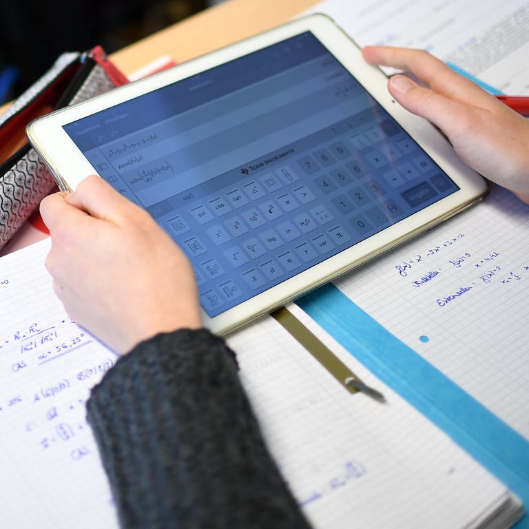 Ein Schüler errechnet eine Gleichung mit einem iPad im Matheunterricht.