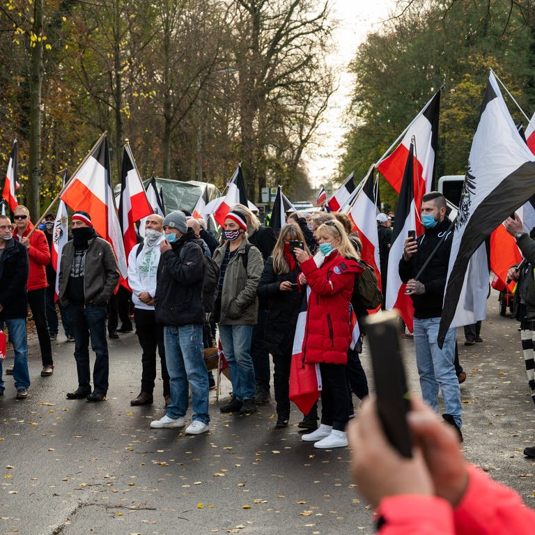 Demonstranten tragen schwarzrotweiße Flaggen. (Foto: dpa Bildfunk, picture alliance/dpa | Christophe Gateau)