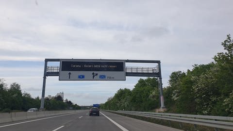 An der Autobahn 5 steht eine elekronische Hinweistafel mit dem Hinweis: "Corona - ostern bitte nicht reisen".