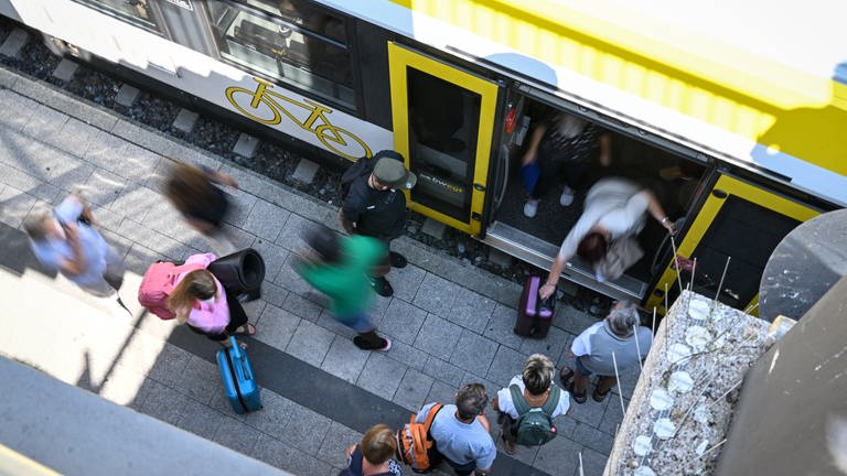 Zugreisende stehen an einem Bahnsteig in Überlingen (Bodenseekreis) bereit, um in einen Zug einzusteigen.  (Foto: dpa Bildfunk, picture alliance/dpa | Felix Kästle)