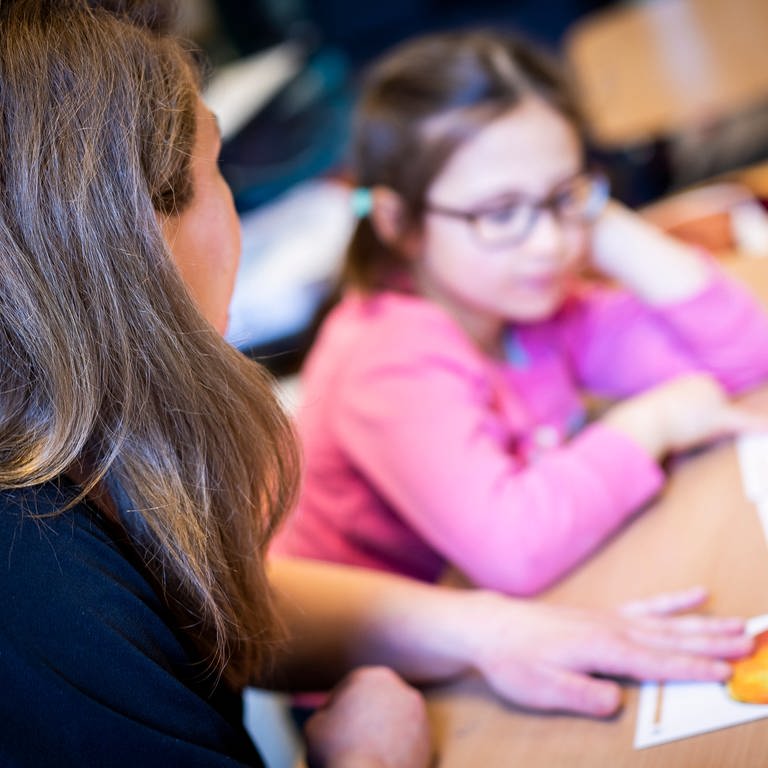 Lehrerin hilft einer Schülerin im Unterricht (Foto: dpa Bildfunk, picture alliance/dpa | Moritz Frankenberg)