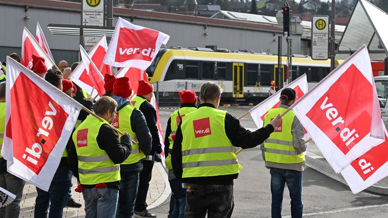 Mitarbeiter der Südwestdeutschen Landesverkehrs GmbH (SWEG) stehen bei einer Kundgebung im Rahmen eines Warnstreiks auf vor dem Bahnhof in Gammertingen. (Foto: dpa Bildfunk, picture alliance/dpa | Bernd Weißbrod)