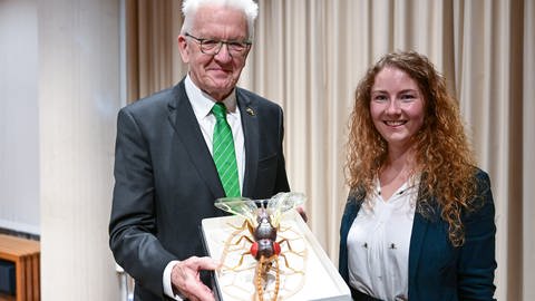 Ministerpräsident Kretschmann zeigt Modell einer Wespenart, die ihm benannt wurde. Neben ihm die Biologin Marina Moser.  (Foto: dpa Bildfunk, picture alliance/dpa | Bernd Weißbrod)