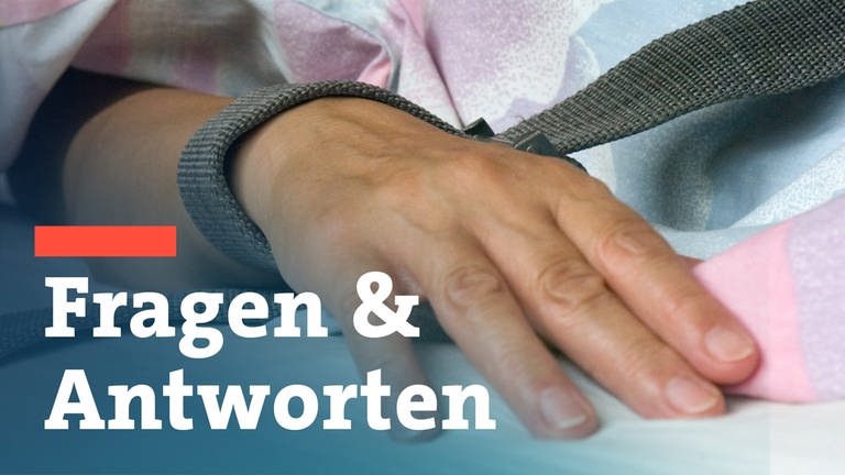 Eine mit einem Textilband festgebundene Hand eines Patienten - die Fixierung bzw. Fixation eines Patienten in der Krankenpflege durch Festschnallen am Handgelenk.