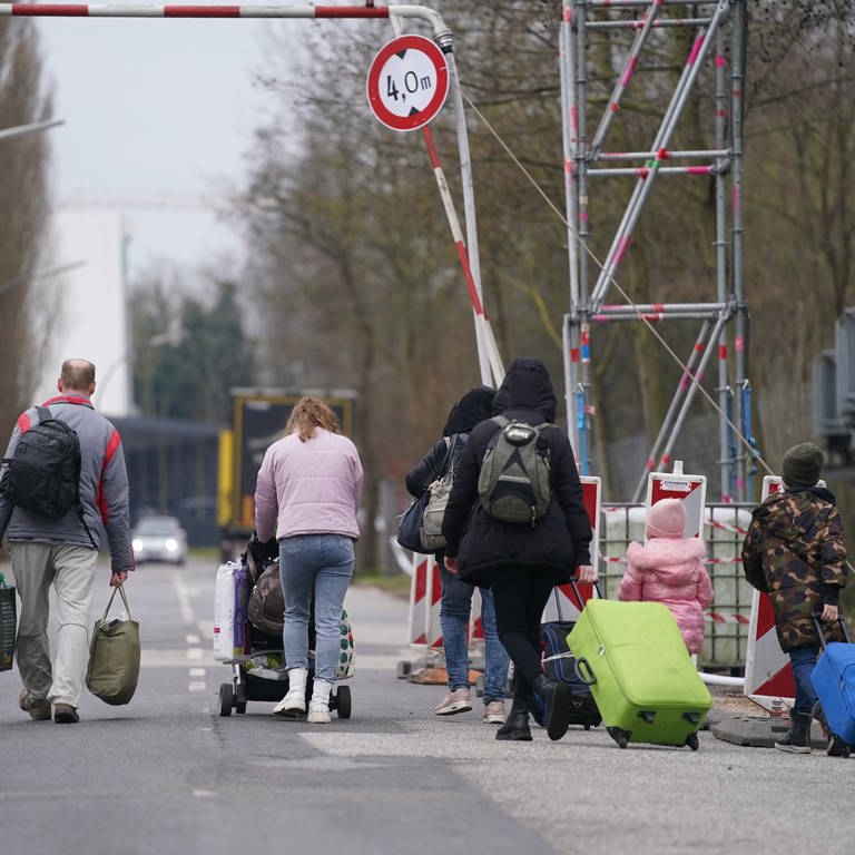 Ukrainische Flüchtlinge verlassen mit ihrem Gepäck die Flüchtlingsunterkunft im ehemaligen Fegro Großmarkt im Stadtteil Harburg.