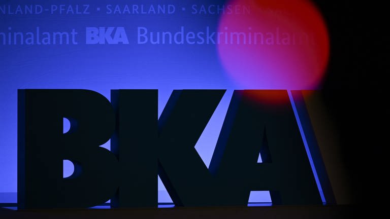 Das Rotlicht einer TV-Kamera leuchtet vor einem großen BKA-Logo. (Foto: dpa Bildfunk, picture alliance/dpa | Arne Dedert)