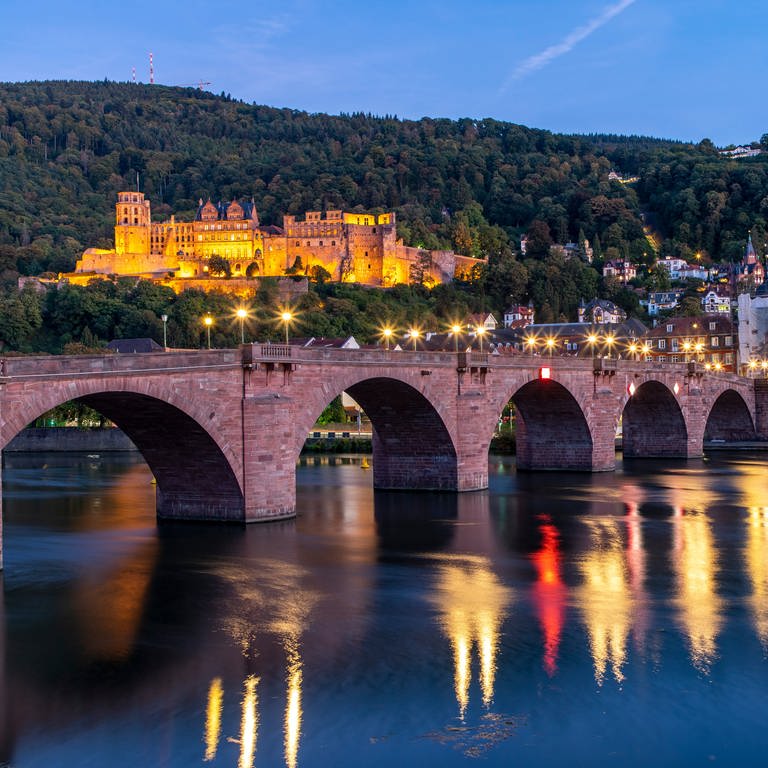 Altstadt von Heidelberg, mit dem Heidelberger Schloss und der Alten Brücke über den Neckar bei Dämmerung.